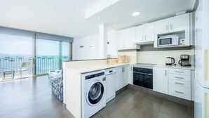 Une cuisine moderne équipée d’un lave-linge, d’un four à micro-ondes et d’une machine à café.