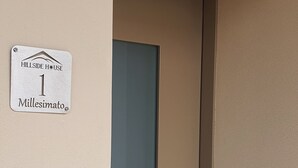 A door with a sign indicating "Hillside House 1, Milessimato."