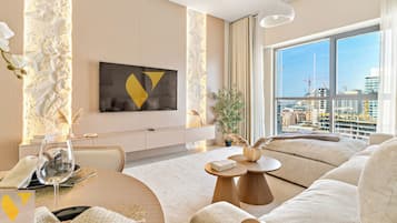 Apartamento de lujo, balcón, vistas a la ciudad | Zona de estar | Smart TV de 65 pulgadas con canales por cable