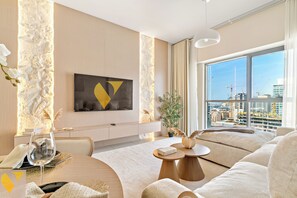 Luxury-Apartment, Balkon, Stadtblick | Wohnbereich | 65-Zoll-Smart-TV mit Kabelempfang
