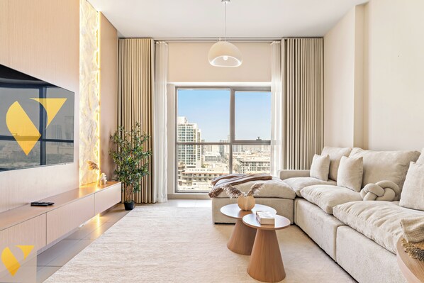 Luxury-Apartment, Balkon, Stadtblick | Wohnbereich | 65-Zoll-Smart-TV mit Kabelempfang