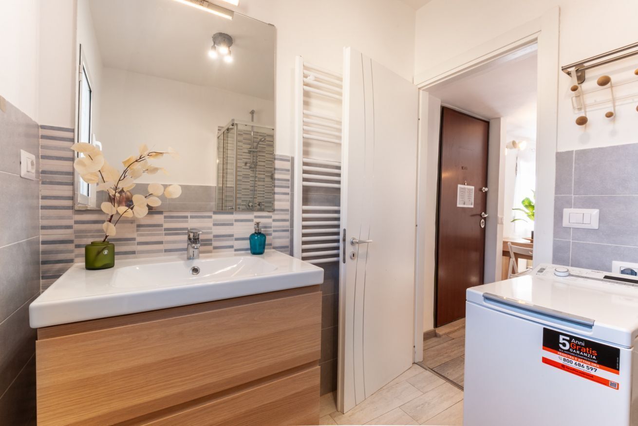 Une salle de bain moderne avec un double lavabo, un miroir, un porte-serviettes et un espace douche.