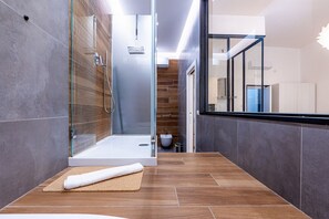 Een douche, een bubbelbad, een bidet, handdoeken