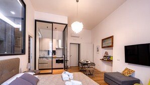 A modern hotel room with a bed, a sofa, a dining area, and a TV. - GuestHost - Spacious and charming 50 square meters studio apartment, perfect for three people, located on the first floor of a building (NO elevator).The property is located in the central area of ​​Salerno (limited traffic zone), a neighborhood well (Salerno)