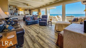Un'ampia zona giorno con vista sull'oceano, una cucina e un'area pranzo.