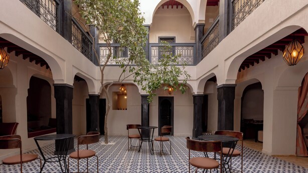 A courtyard with tiled flooring, multiple tables and chairs, and a central tree. - Riad Cedrat (Marrakech)