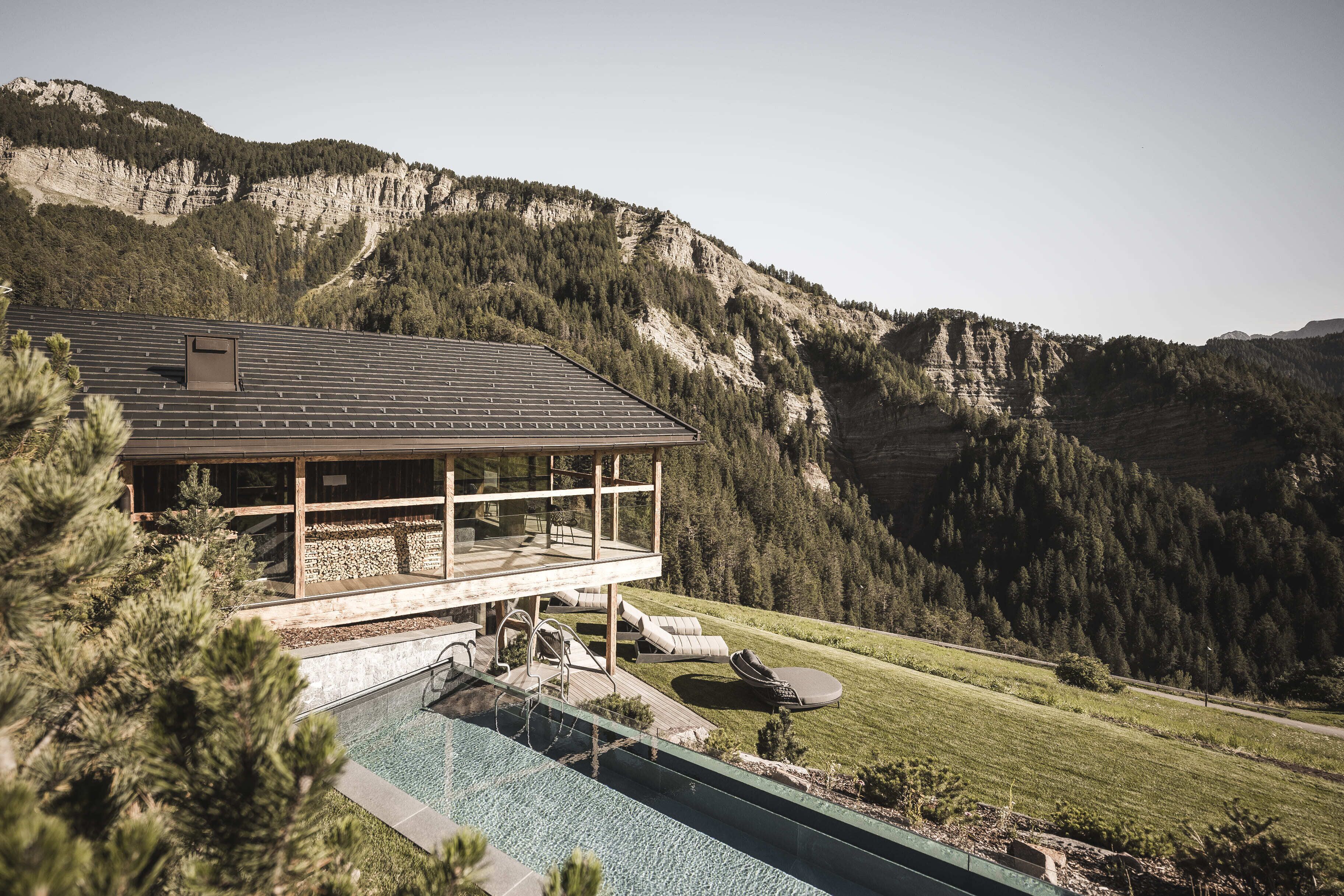 A modern house with a pool, overlooking a mountainous landscape.