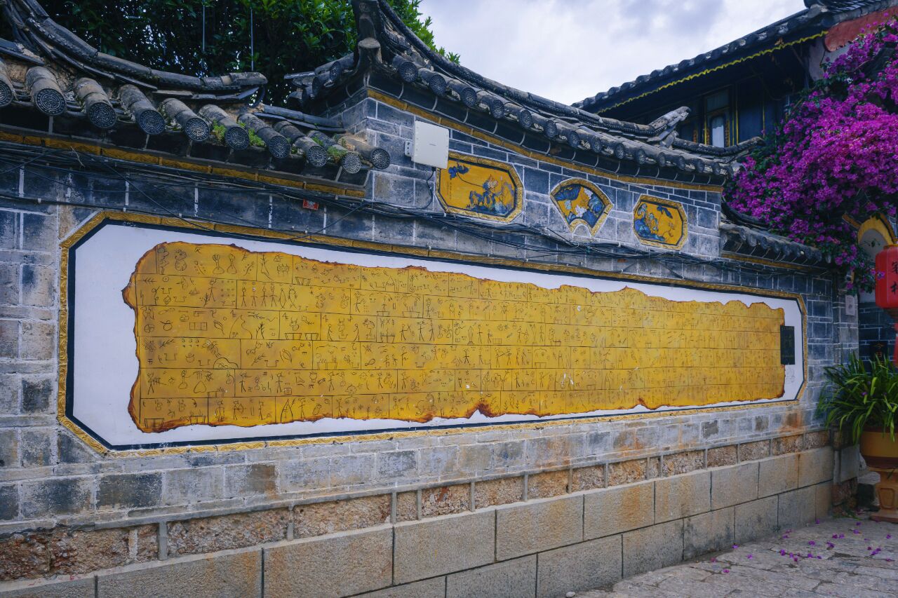 A traditional building with a tiled roof and a large wall with inscriptions.