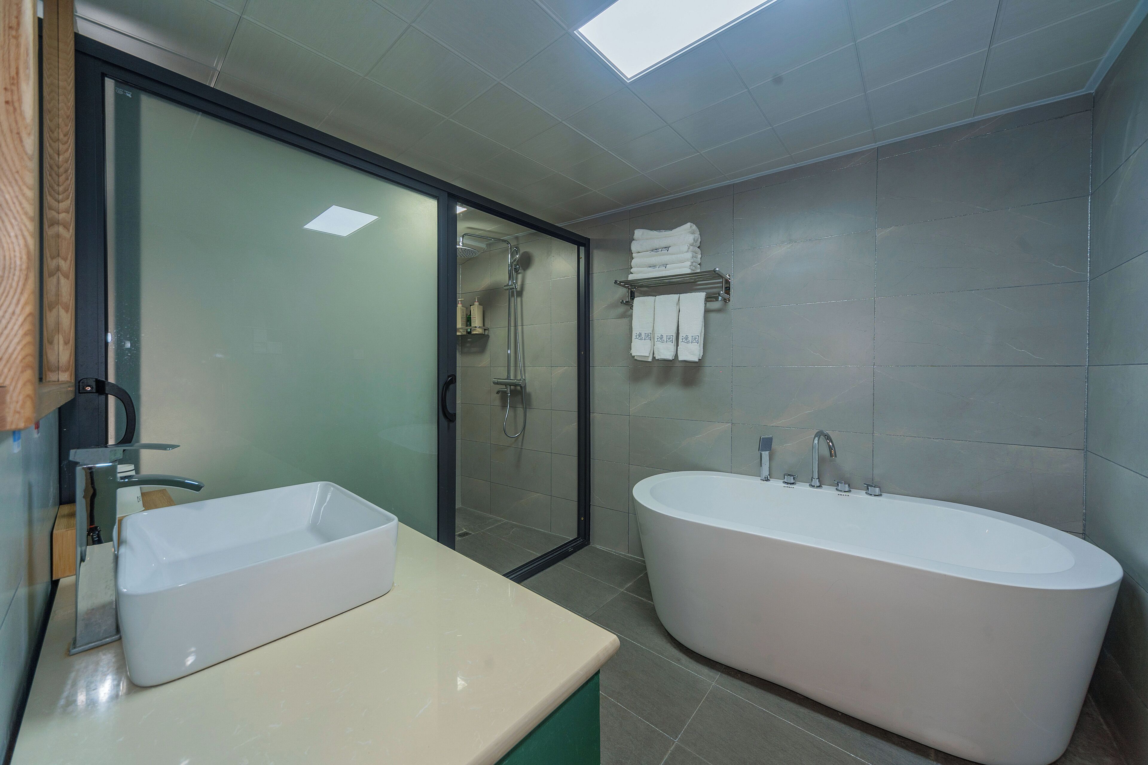 Ein modernes Badezimmer mit einer großen Badewanne, einem Waschbecken und einer Duschkabine aus Glas.