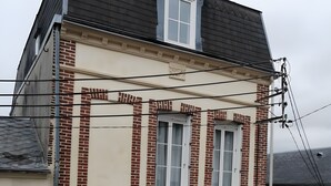 A two-story building with a brick facade, multiple windows, and a visible door. - Gîte De La Voûte in Fécamp with Wi-Fi (Fécamp)