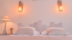A bed with white bedding and a lamp, two wall-mounted light fixtures, and a wooden headboard. - Gîte De La Voûte in Fécamp with Wi-Fi (Fécamp)