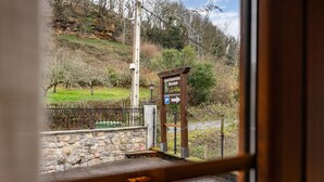A stone wall, a metal fence, and a sign with an arrow pointing right. - Apartment 'La Viña 3' with Mountain Views and Wi-Fi (Corao)
