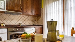 A kitchen with wooden cabinets, a microwave, a coffee maker, and a table with a glass of juice and a croissant. - Apartment 'La Viña 7' – Perfect for Couples' Getaways (Corao)