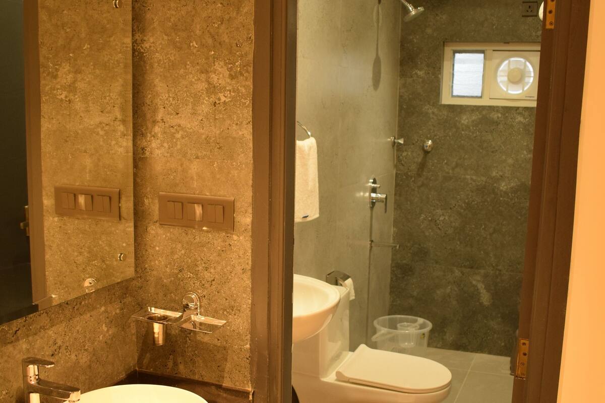 A bathroom with a large sink, mirror, and shower.