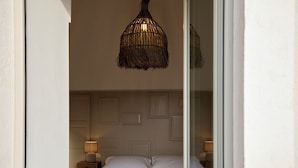 Ein Schlafzimmer mit einem Bett, Nachttischlampen und einem gewebten Lichtschirm.