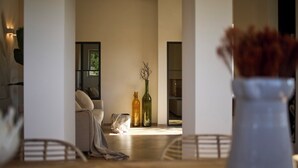Ein modernes Wohnzimmer mit einer Couch, einem Couchtisch und zwei Flaschen auf einem Beistelltisch.