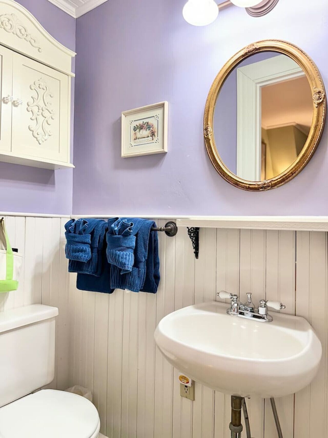 A bathroom with a white sink, a toilet, and a vanity with a mirror.