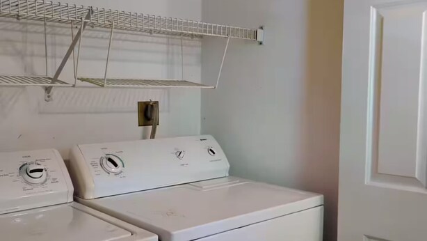 A laundry room with two stacked washers and dryers, a metal drying rack, and a door. - Charming Guesthouse (Middleton)
