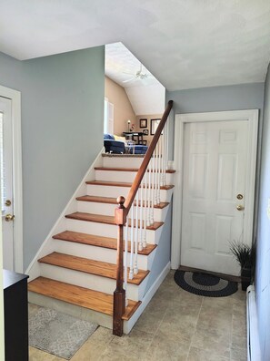 A staircase with wooden steps and white railings leading to a landing.