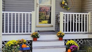 A house with a porch, a door with a glass panel, and potted plants. - Charming Guesthouse (Middleton)