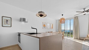 A modern kitchen with a central island, a built-in oven, and a pendant light. - Casa María Luisa: Panoramic Terrace, Spectacular Gibraltar Views & Separate Studio (Manilva)
