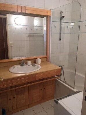 A bathroom with a wooden vanity, a sink, a mirror, and a glass shower enclosure. - Ideal stay in the heart of the ski slopes (Val-d'Isère)