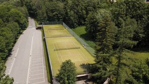 An aerial view of a tennis court surrounded by dense forest. - Superb apartment in Megève (Megève)