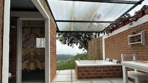 A modern outdoor bathroom with a glass-enclosed shower, a white sink, and a bathtub. - La Villa The View (Cali)