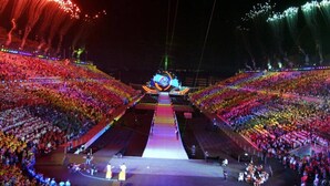 Eine große, überdachte Arena mit abgestuften Sitzplätzen und einer zentralen Bühne.