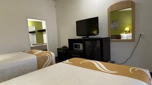 Een hotelkamer met twee bedden, een televisie, een magnetron en een spiegel.