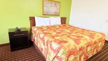 A hotel room with a bed, a nightstand, a telephone, and a painting on the wall.