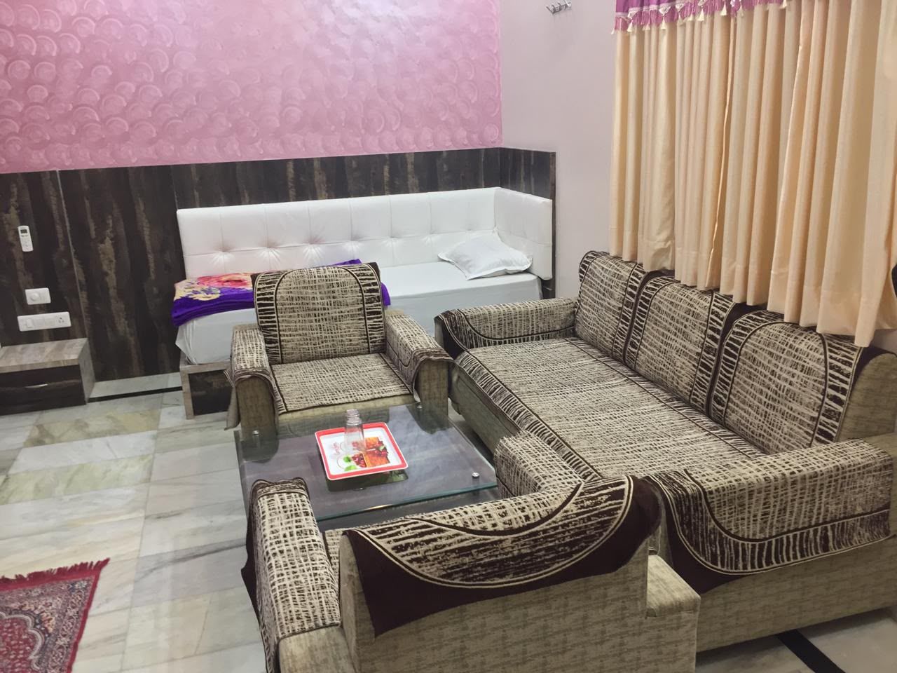 Un salon avec un canapé, des fauteuils et une table basse.