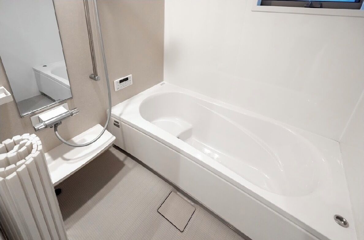 A modern bathroom with a white bathtub, a sink, and a mirror.