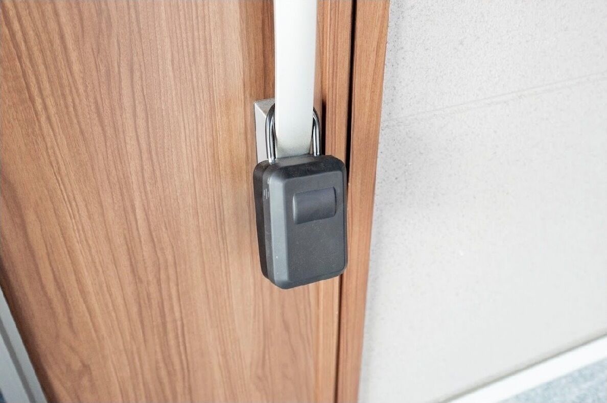 Une porte avec une poignée noire et un tuyau blanc.