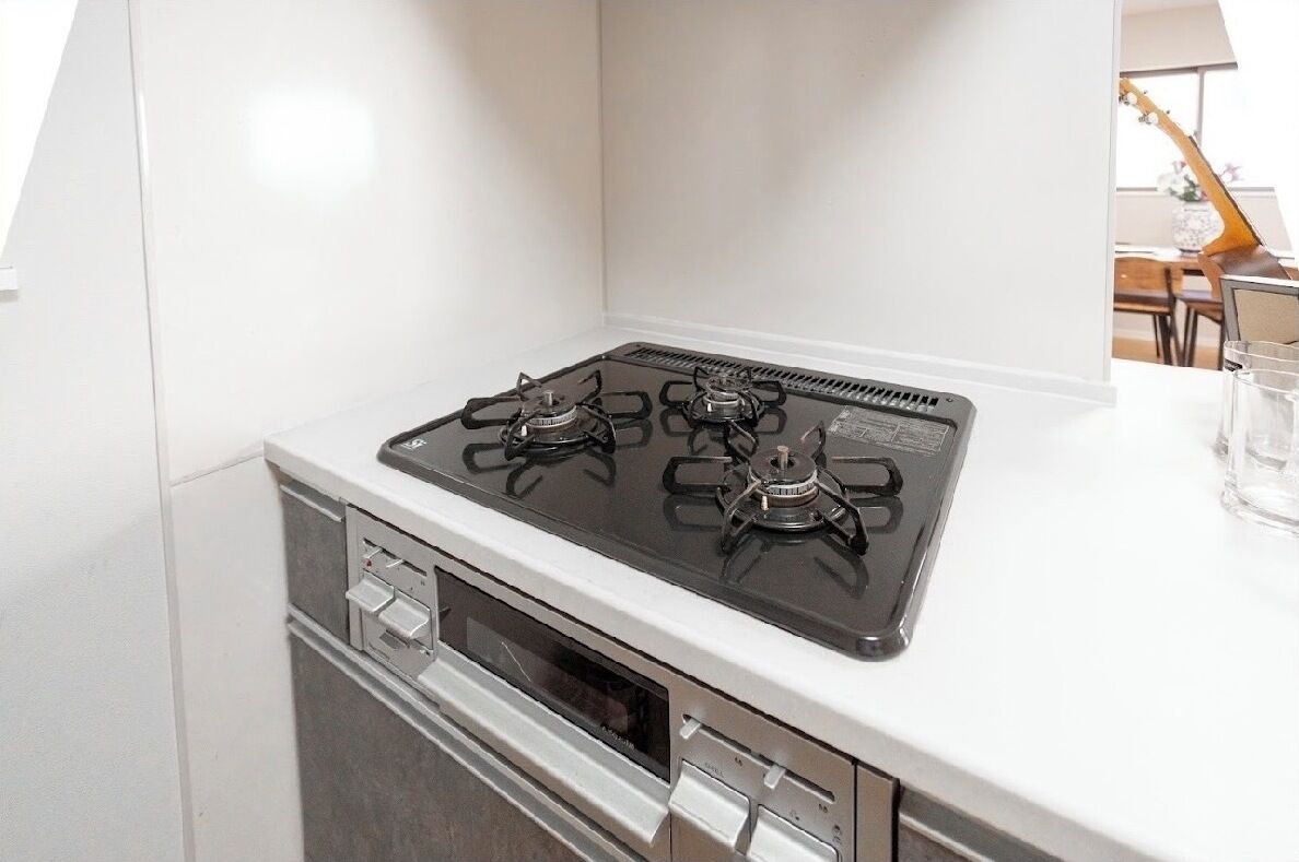 A kitchen with a four-burner gas stove, a microwave, and a built-in oven.