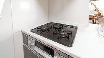 A kitchen with a four-burner gas stove, a microwave, and a built-in oven.