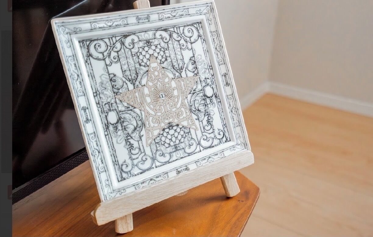 A framed artwork on a wooden easel.