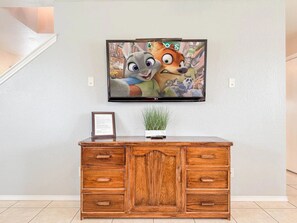 A wooden cabinet with drawers and a flat-screen TV mounted on the wall above it. - Spacious 4br 2half 5bh  Family Fun Huge Yard (San Antonio)