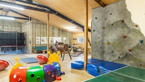 Eine Kletterwand, gedämpfte Böden und ein Trampolin in einem Erholungsbereich.