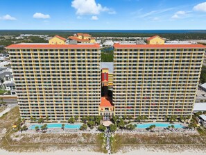 A large hotel with multiple floors, a central pool, and a beach area. - ☀️Stunning Beach Front-Tiki Bar-Pools-Calypso 1-706☀️ (Panama City Beach)