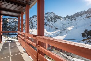 A wooden balcony with a view of snow-covered mountains. - 'Bero Bisto La Mongie' Apartment with Mountain View and Balcony (Bagnères-de-Bigorre)