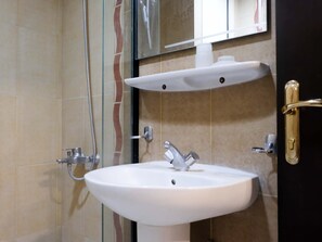 A bathroom with a white sink, a handheld showerhead, and a mirror above the sink. - Meezab Alkher Hotel (Makkah)