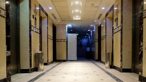 A corridor with marble floors and walls, leading to a door at the end. - Meezab Alkher Hotel (Makkah)