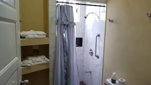 Een badkamer met een douche, toilet en handdoekrek.