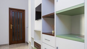 A room with a wooden door, white shelving units, and a green countertop. - VomeroMetroNest By Dimorra  (Napoli)