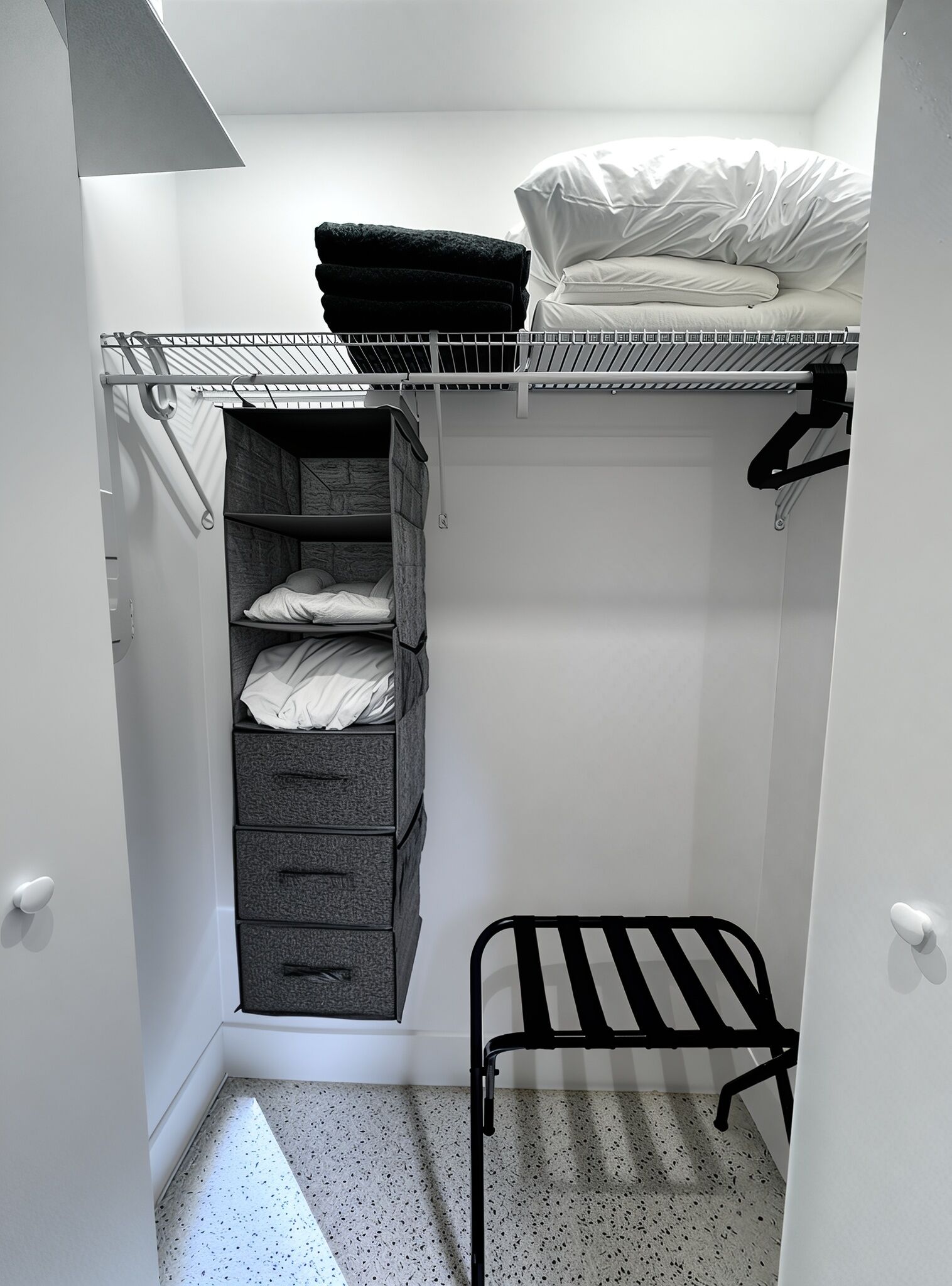 A compact storage closet with a hanging rack, open shelving, and a fold-down desk.