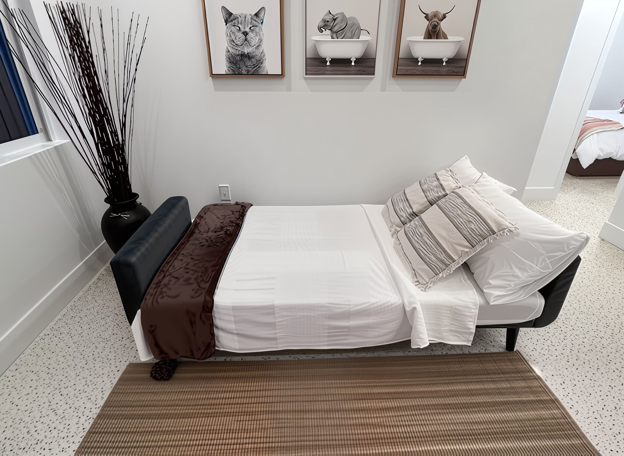 A bedroom with a bed, a bedside table, a lamp, and three framed pictures on the wall.