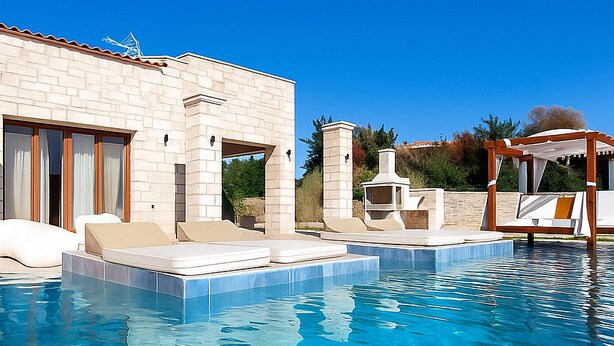 Una piscina con sillones de descanso, una pérgola y un edificio de piedra con chimenea.