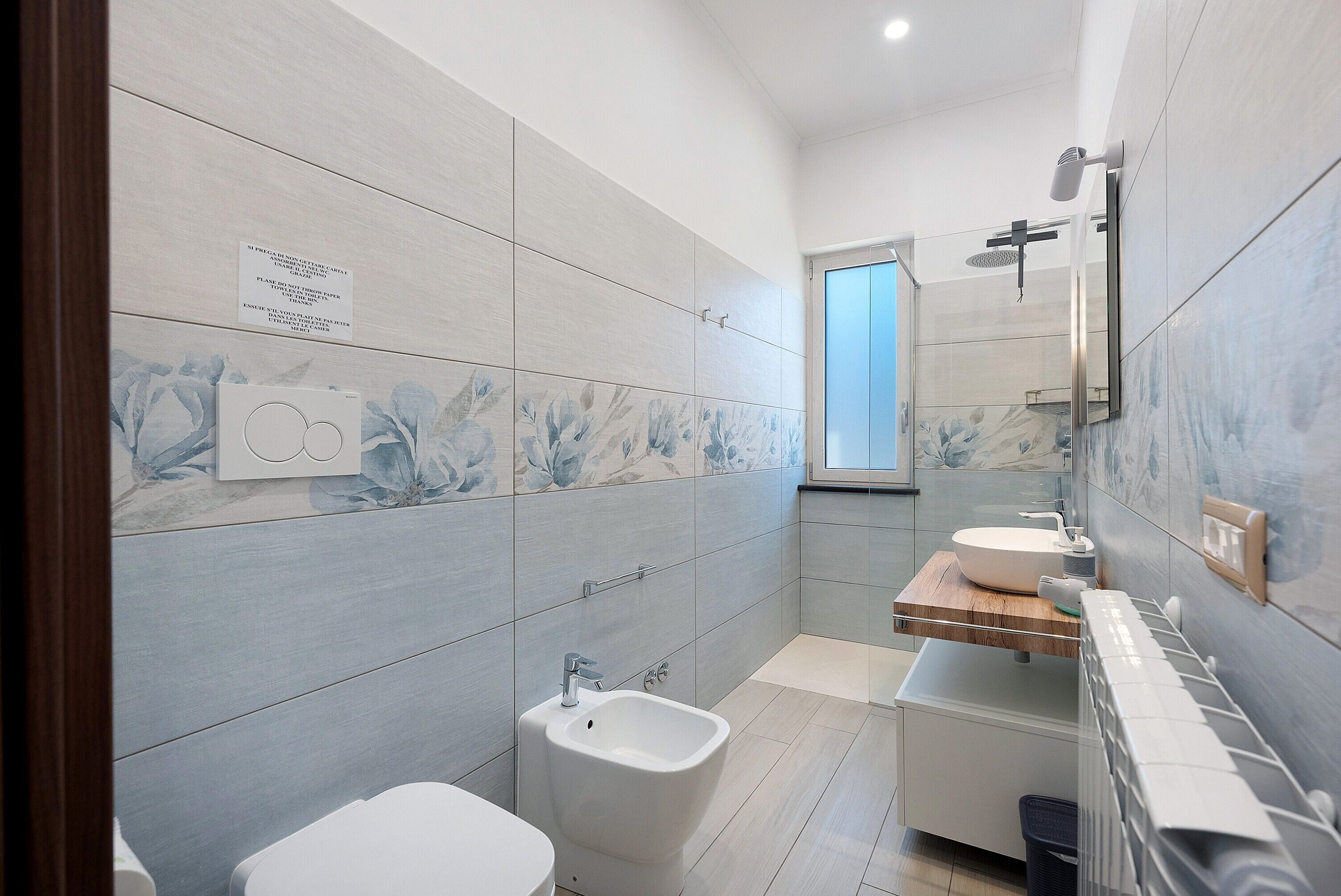 Un bagno moderno con bidet, lavandino e specchio.