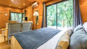 Camera da letto in una baita di legno con un letto, una scrivania e un'ampia finestra.